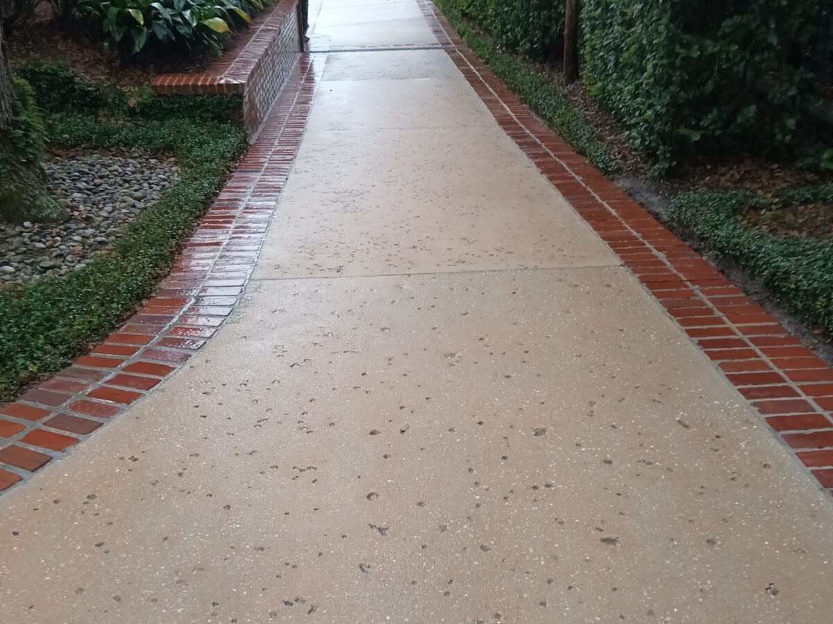Pressure washing near me in St Cloud, FL addressing organic residue on a shaded patio near a waterfront residence
